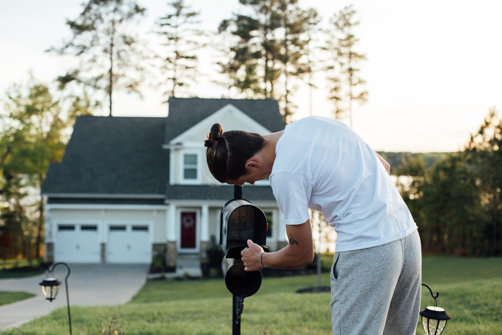 Homeowner checking mail at a curbside mailbox
